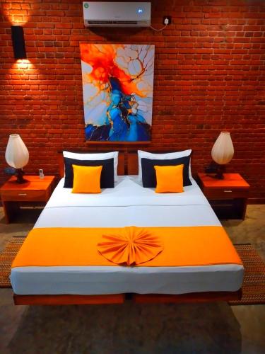 a bedroom with a large bed with an orange blanket at Eliyanth Udawalawe in Udawalawe