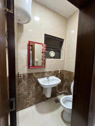 a bathroom with a sink and a toilet and a mirror at Osama Alnaser in Amman