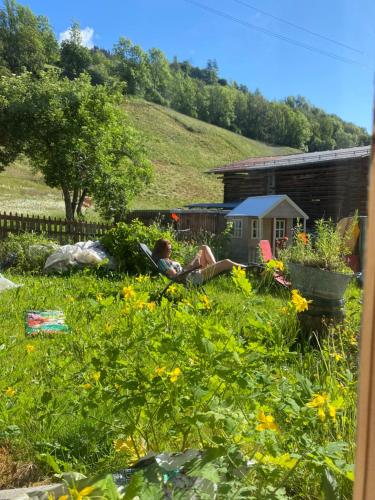 a woman laying in the grass in a garden at Casa Vegana 4,5 Zimmer 8Pl, 3 Badezimmer in Trun