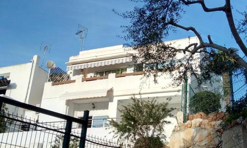 a white house with a fence in front of it at Beach Suite Playa Cala dor in Cala d´Or