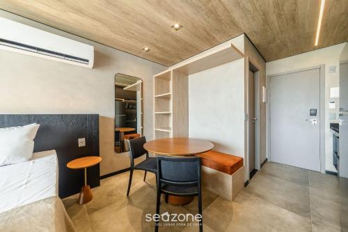 a small room with a bed and a table and a bed and a bedroom at NWTs - Estúdios em Prédio com Vista Mar in Maceió