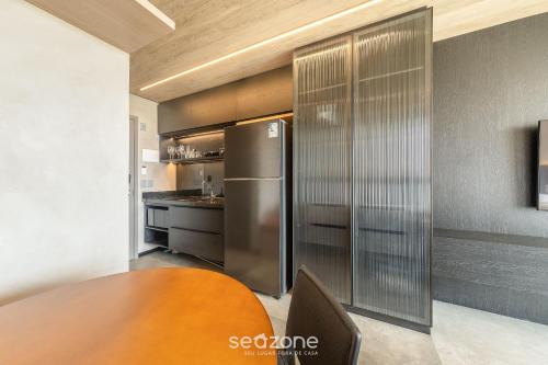 a kitchen with a stainless steel refrigerator and a table at NWTs - Estúdios em Prédio com Vista Mar in Maceió