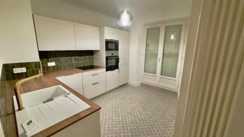 une cuisine avec des armoires blanches et un comptoir dans l'établissement Le Richebourg - Place Wilson, Centre Ville, à Dijon