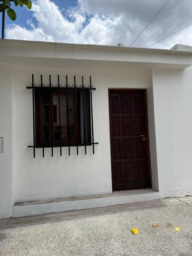 a white building with a door and a window at Doña Cielo in Cafayate