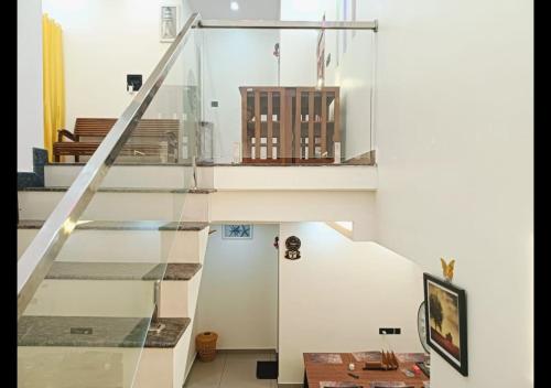 a glass staircase in a house at Pepper Jazz Varkala in Varkala