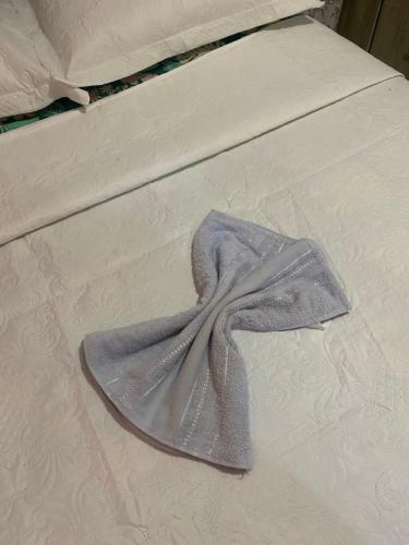 a blanket on a bed with a dress on it at Casa de temporada sonho de verão in Piranhas