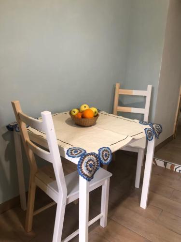 a table with a bowl of fruit and two chairs at Casa Vacanze Il Vicolo - Oliveto Citra in Oliveto Citra