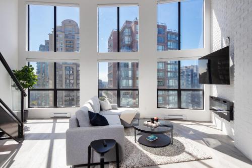 a living room with large windows and a couch at Loft in Entertainment District with FREE underground Parking in Vancouver