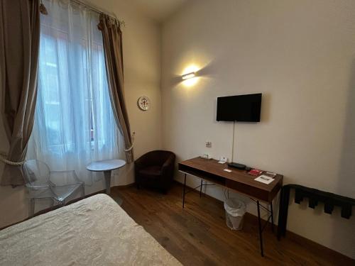 una camera d'albergo con una scrivania e una televisione di Casa Salbego R&B a Bologna