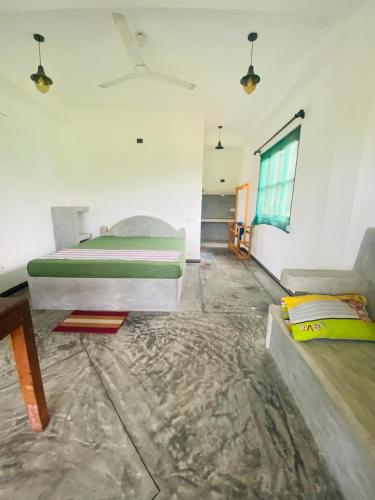 a bedroom with a bed and a couch and a window at southern grace hotel in Unawatuna