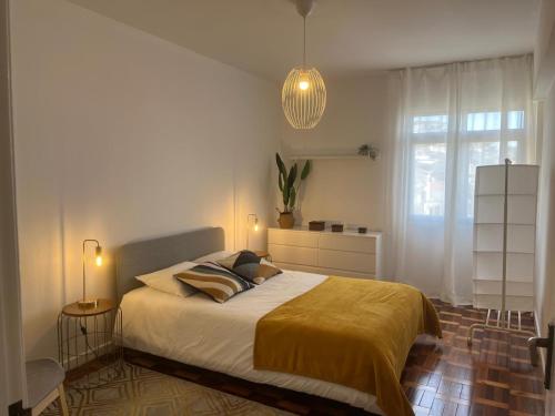 a bedroom with a large bed and a window at Cantinho dos M&M in Funchal