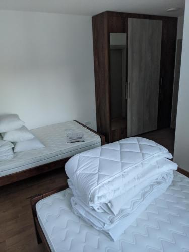 a bed with white sheets on it in a room at Villa Evergreen in Kopaonik