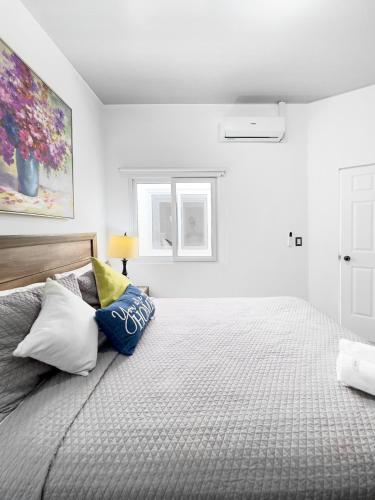 a white bedroom with a large bed with pillows at Modern Retreat in San Miguel