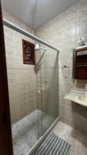 a shower with a glass door in a bathroom at Regi House Hostel in Vitória