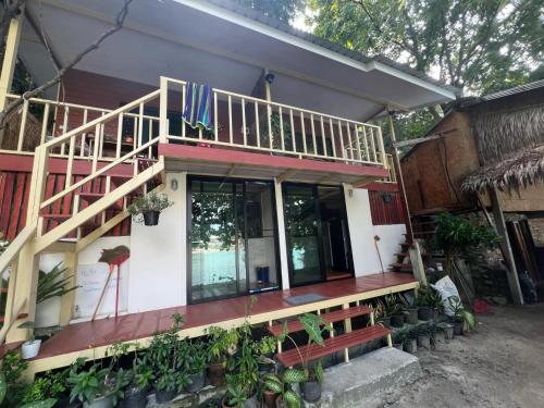 a house with a staircase and a balcony at Smiley Bungalows Guesthouse in Srithanu