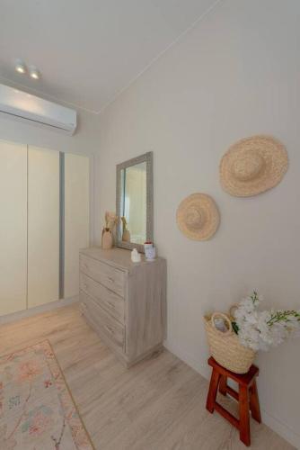 a room with a dresser with a mirror and a chair at Stylish 3 BR Retreat at Ancient Hills El Gouna in El Gouna