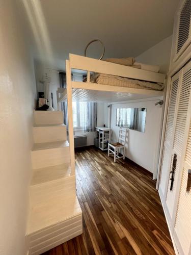 une chambre avec des escaliers et un lit superposé dans l'établissement Cocon à 5 min de Paris, à Maisons-Alfort