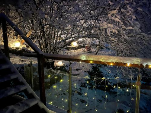 a fence covered in snow at night with lights at Chalet des roches - Plainfaing in Plainfaing