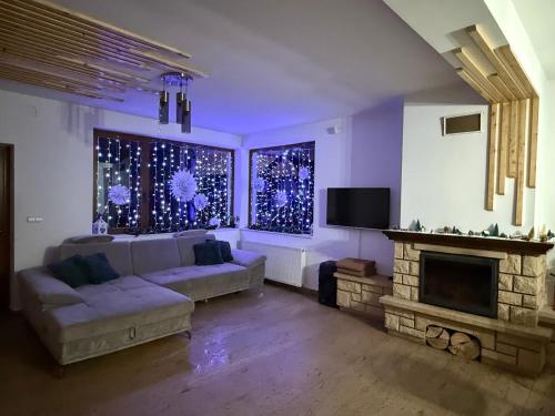 Una sala de estar con un sofá y una chimenea. en Eden Chalet, Cabana Eden, en Firiza-de-Jos