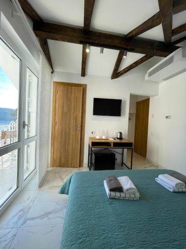 a bedroom with a bed and a desk and a television at Ancora Hotel in Herceg-Novi