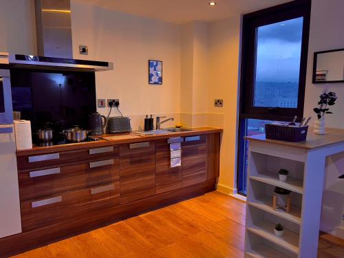a kitchen with a large wooden counter with a large window at Penthouse Gem, Central, Scenic Views, Stylish, Modern, City Centre 2BR in Sheffield