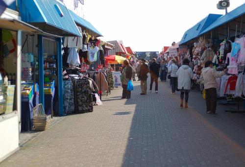 a group of people walking down a street in a market at Serenity - Luxury Hot Tub, Sunnymede, Fantasy Island, , Ramped Access, Parking, Dog Friendly in Ingoldmells