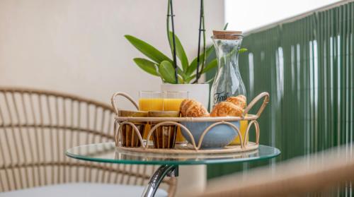 - un plateau de croissants et de jus d'orange sur une table en verre dans l'établissement Studio moderne chaleureux et calme, à Annecy