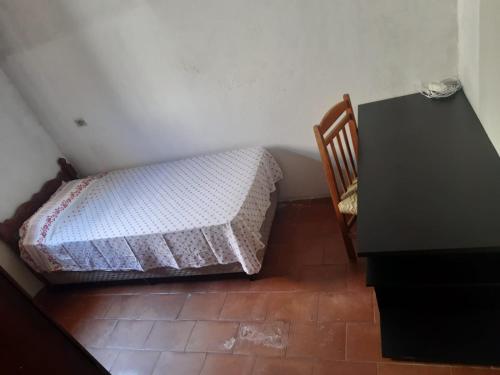 a small bed in a room next to a desk at Hostel Sancris 2 in São José dos Campos