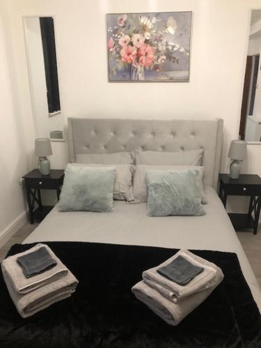 a bedroom with a large bed with two towels on it at 1 Bed-Park View-Balcony-WiFi-Pet Friendly in London