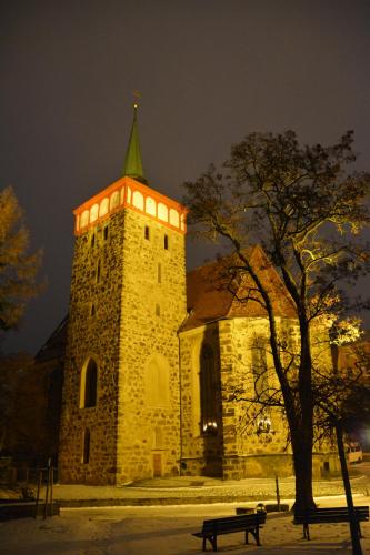 a building with a tower with a tree and a bench at Ferienappartements "Landromantik" in Bautzen