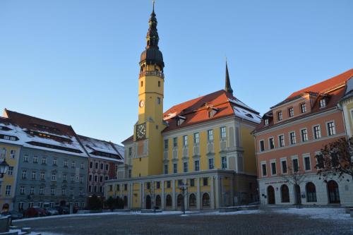 a yellow building with a clock tower in a city at Ferienappartements "Landromantik" in Bautzen