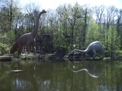 two dinosaurs standing in the water next to a lake at Ferienappartements "Landromantik" in Bautzen