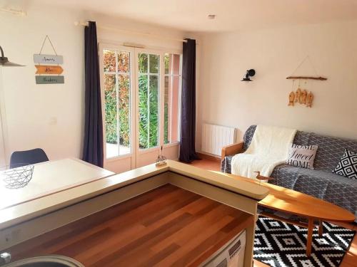 un salon avec un canapé et une table dans l'établissement Maison charmante à Lacanau avec piscine partagée et terrasse, à Lacanau