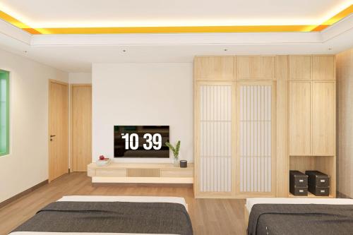 a bedroom with two beds and a tv on a wall at Luna Sol Villas - Dedicated Care Until Check Out in Phu Quoc