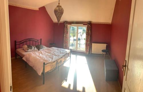 - une chambre avec un lit dans un mur rouge dans l'établissement Riad 1001 Nights, à Toges