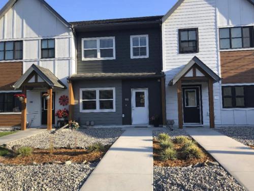 a house with a black and white at Stanley Townhomes by StayIn in Radium Hot Springs