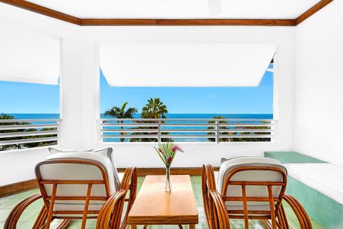a dining room with a table and chairs and the ocean at Couples Swept Away in Negril