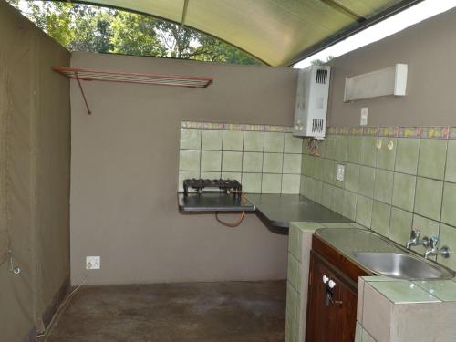 a kitchen with a sink and a counter top at Sabie River Camp in Sabie