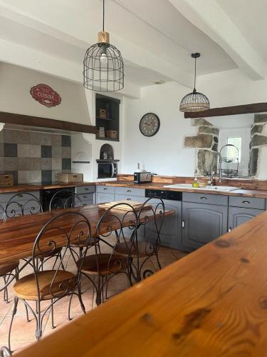 une grande cuisine avec une table et des chaises en bois dans l'établissement Penty Yves 10 personnes, à Crozon