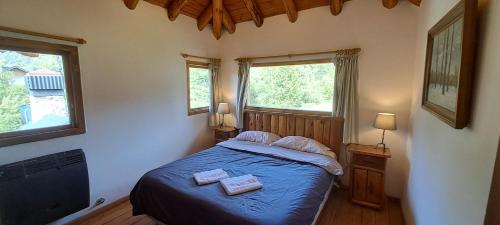 a bedroom with a bed with two towels on it at Casa Nico in San Carlos de Bariloche