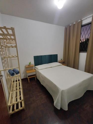 a bedroom with a large bed and a ladder at Cê Achegue Aqui Uai in Contagem