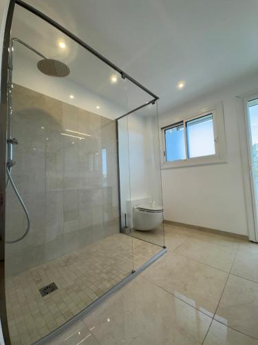 une salle de bain avec une douche en verre et des toilettes dans l'établissement La Roseraie - Apt Standing 4 Prs - Piscine - Parking, à Antibes