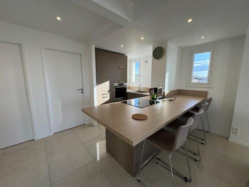 une cuisine avec une grande table et des chaises en bois dans l'établissement La Roseraie - Apt Standing 4 Prs - Piscine - Parking, à Antibes