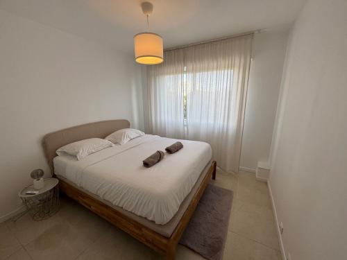 - une chambre avec un lit doté d'un sac brun dans l'établissement La Roseraie - Apt Standing 4 Prs - Piscine - Parking, à Antibes