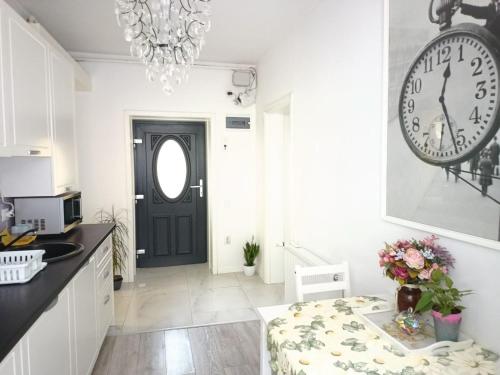 a kitchen with a black door and a clock on the wall at Old Town Cozy Nest in Sibiu