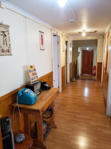 an empty room with a table and a hallway at Magellanic House in Puerto Natales