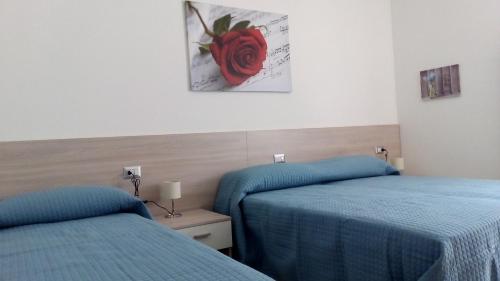 a room with two beds and a painting on the wall at Casa Rondine in Molveno