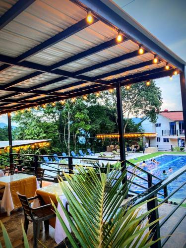 a patio with a pool with tables and chairs at Hotel Zipa Villeta - Sede Campestre in Villeta