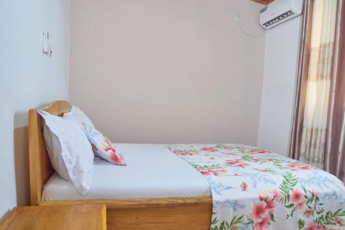 a bedroom with a bed with a pillow and a window at Cosy Refuge in Bonabéri