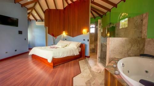 a bedroom with a bed and a bath tub at Arenal Tropical Home Villa in Fortuna